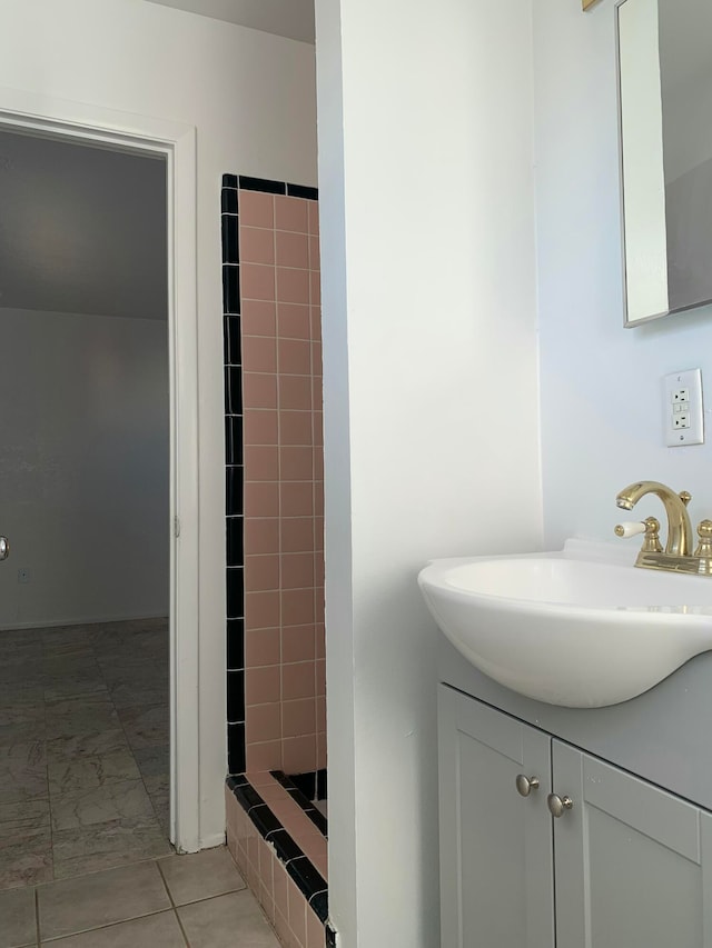 bathroom featuring tiled shower and vanity