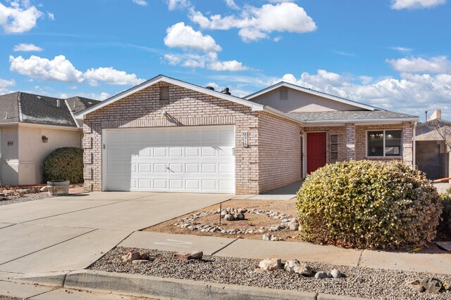 single story home featuring a garage, concrete driveway, and brick siding