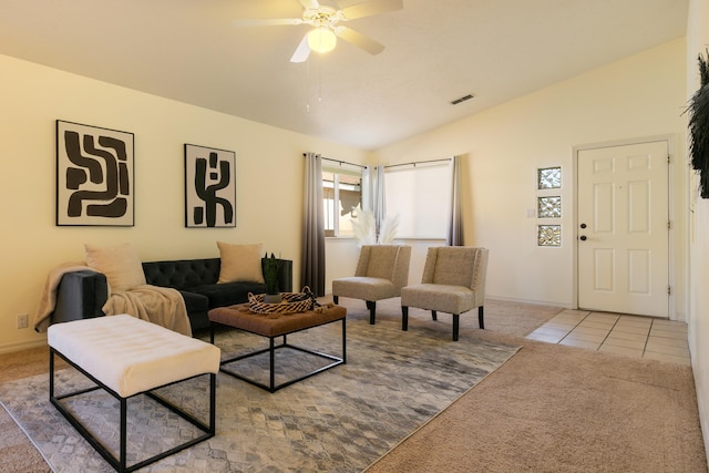carpeted living area with ceiling fan, visible vents, baseboards, vaulted ceiling, and tile patterned floors