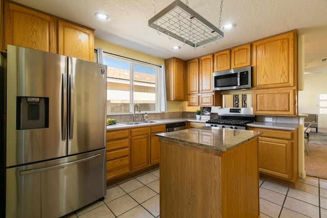 kitchen featuring light tile patterned floors, stainless steel appliances, a kitchen island, and a sink