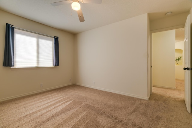 unfurnished room with baseboards, light carpet, and ceiling fan