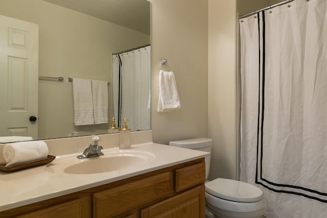 bathroom featuring curtained shower, toilet, and vanity