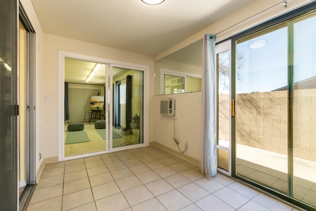 doorway to outside featuring light tile patterned floors, plenty of natural light, and baseboards