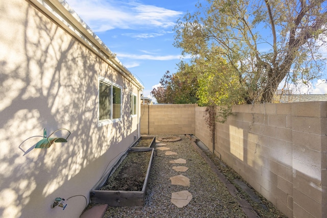 view of side of property with a fenced backyard and stucco siding