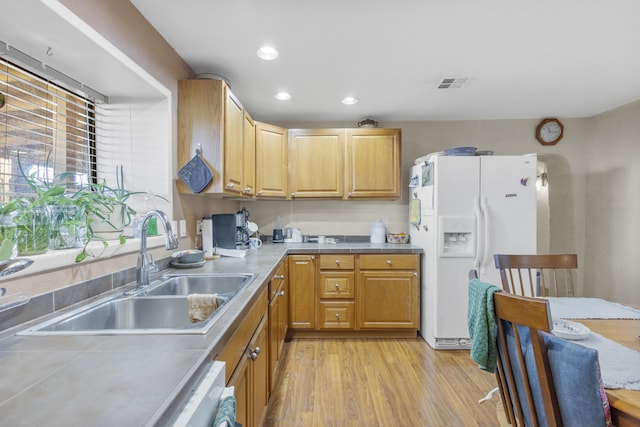 kitchen featuring sink, a healthy amount of sunlight, white appliances, and light hardwood / wood-style floors