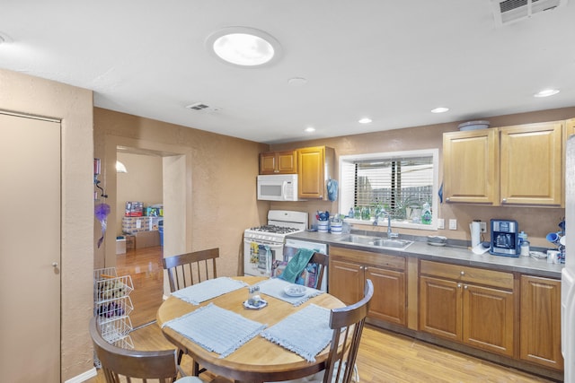 kitchen featuring white appliances, sink, and light hardwood / wood-style flooring