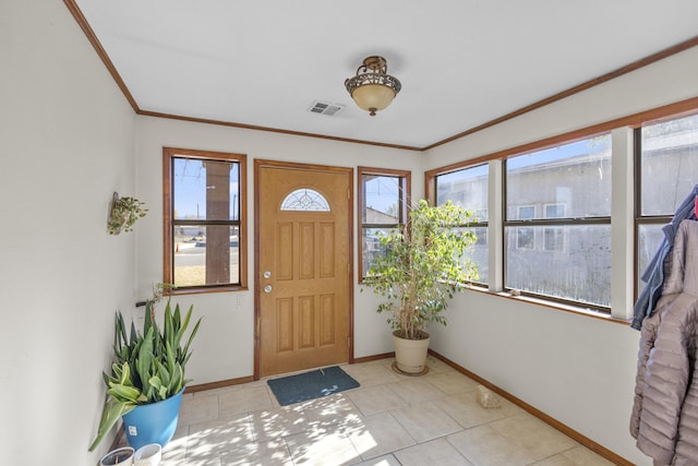 foyer with plenty of natural light, light tile patterned flooring, and ornamental molding