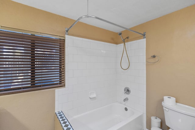 bathroom with toilet and tiled shower / bath