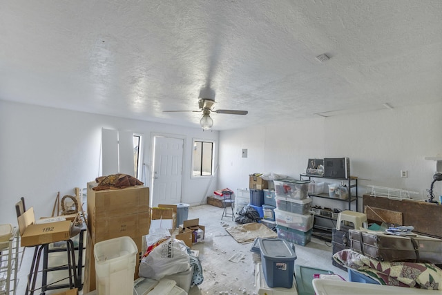 interior space with ceiling fan and a textured ceiling