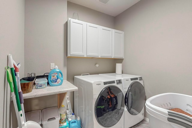 washroom featuring washer and dryer and cabinets