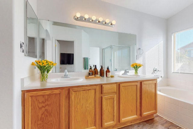 bathroom with vanity, wood-type flooring, and shower with separate bathtub