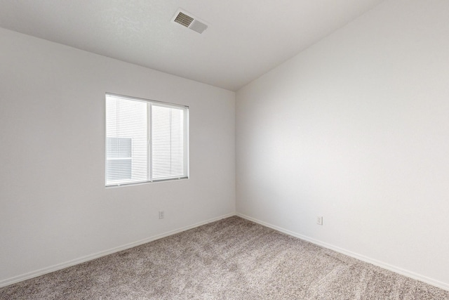 empty room featuring carpet and lofted ceiling