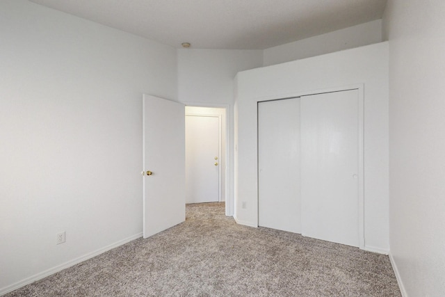 unfurnished bedroom with light carpet and a closet