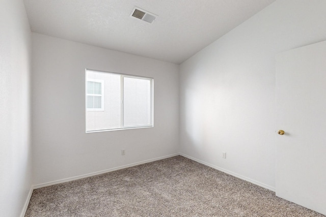 spare room featuring light carpet and lofted ceiling