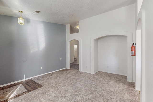 carpeted spare room with a textured ceiling