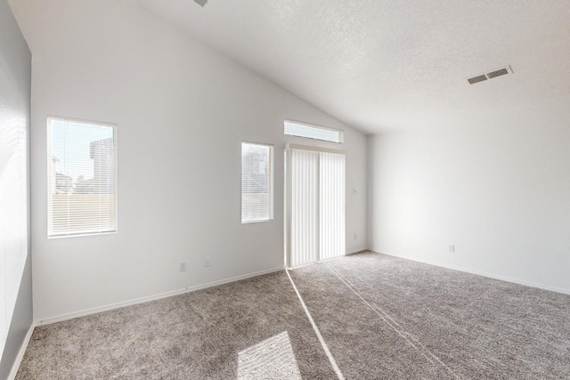 unfurnished bedroom featuring carpet, multiple windows, and lofted ceiling