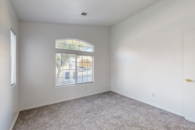 carpeted spare room featuring lofted ceiling