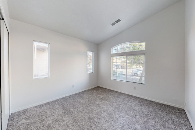 unfurnished room featuring carpet and vaulted ceiling