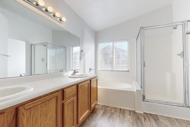 bathroom featuring plus walk in shower, hardwood / wood-style floors, vanity, and lofted ceiling