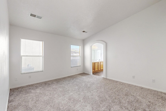 carpeted spare room with a textured ceiling