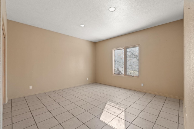 empty room featuring light tile patterned floors and a textured ceiling