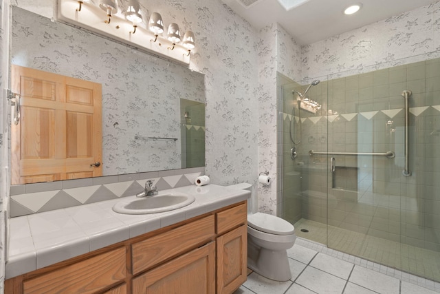 bathroom featuring tile patterned flooring, vanity, toilet, and an enclosed shower