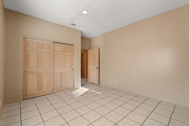 unfurnished bedroom featuring a closet and light tile patterned flooring