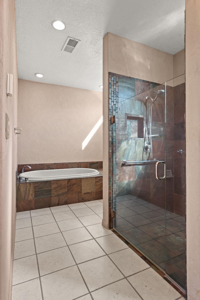 bathroom featuring tile patterned flooring, a textured ceiling, and independent shower and bath