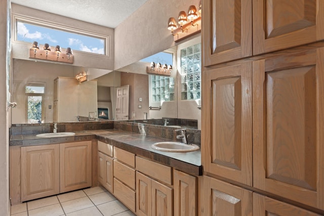 bathroom featuring tile patterned floors, vanity, a textured ceiling, and a wealth of natural light