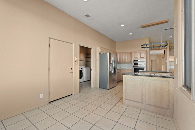 kitchen with light tile patterned floors, separate washer and dryer, light brown cabinetry, appliances with stainless steel finishes, and kitchen peninsula