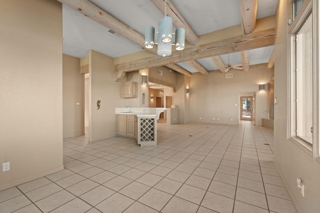 kitchen featuring kitchen peninsula, sink, beam ceiling, a breakfast bar area, and light tile patterned flooring