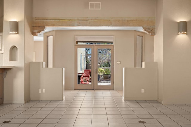 entryway with light tile patterned floors and french doors