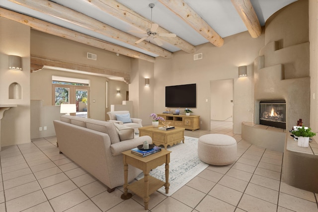 living room with beamed ceiling, light tile patterned floors, french doors, and ceiling fan