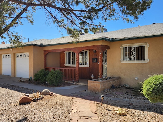 ranch-style house featuring covered porch and a garage