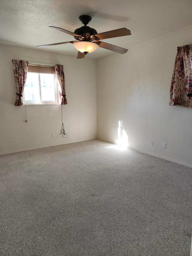 carpeted empty room with ceiling fan and a textured ceiling