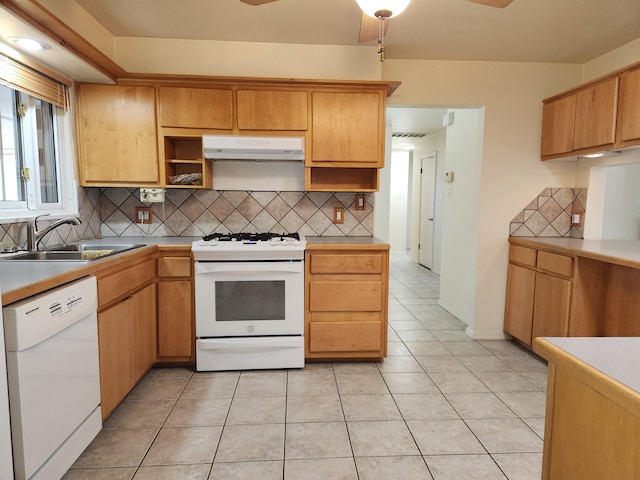 kitchen with decorative backsplash, light tile patterned floors, white appliances, and sink