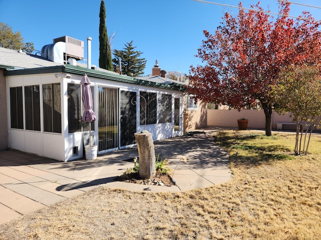 rear view of house featuring a patio area and a sunroom