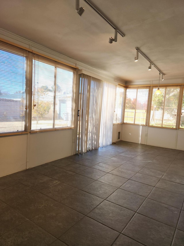 unfurnished sunroom with track lighting