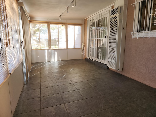 unfurnished sunroom featuring track lighting