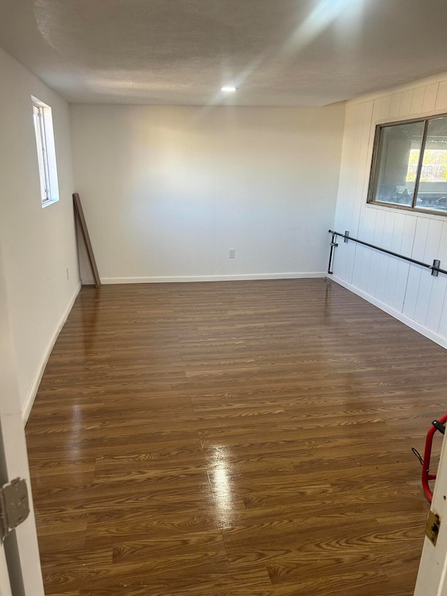 unfurnished room with a textured ceiling and dark hardwood / wood-style flooring