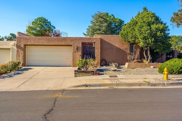 pueblo revival-style home featuring a garage