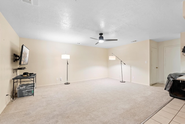 living room featuring light carpet, ceiling fan, and a textured ceiling