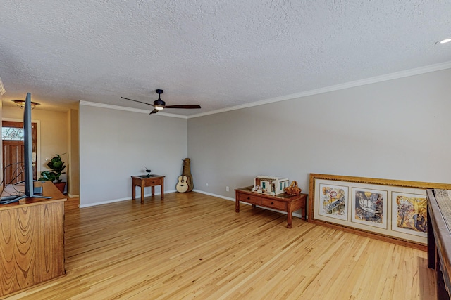 living area featuring ceiling fan, ornamental molding, light hardwood / wood-style flooring, and a textured ceiling