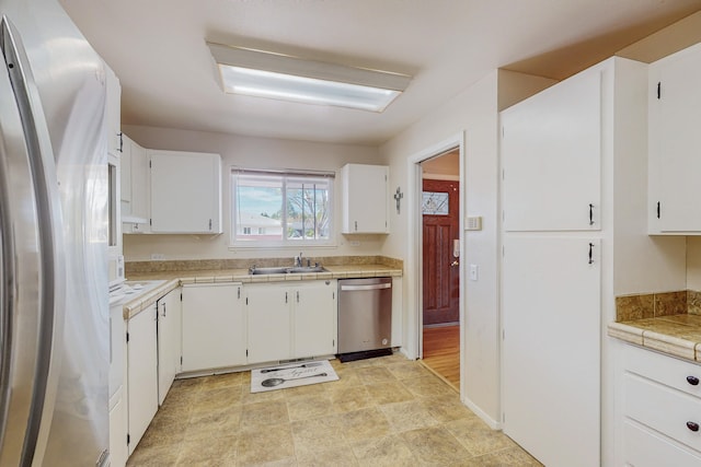 kitchen with stainless steel appliances, white cabinetry, and sink