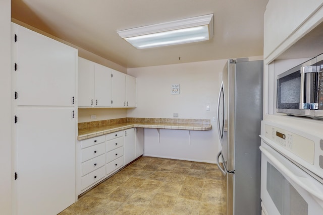 kitchen with white cabinetry and appliances with stainless steel finishes