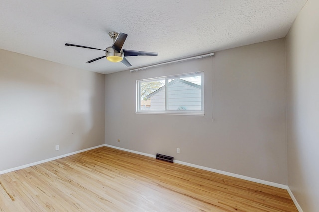 spare room featuring ceiling fan, wood-type flooring, and a textured ceiling