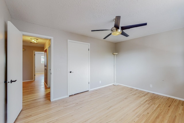 unfurnished bedroom featuring a textured ceiling, ceiling fan, and light hardwood / wood-style floors