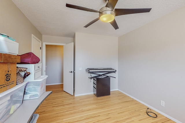 interior space with ceiling fan, a textured ceiling, and light wood-type flooring