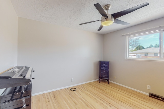 interior space featuring ceiling fan, a textured ceiling, and light wood-type flooring