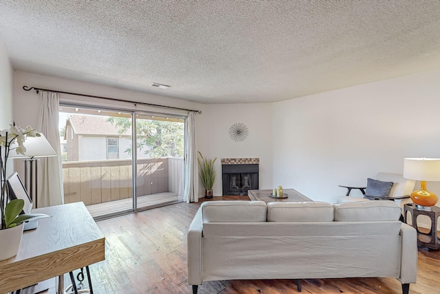 living room with a textured ceiling and light hardwood / wood-style floors